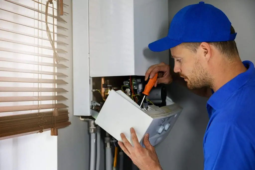 House gas heating boiler maintenance and repair service. worker in blue uniform